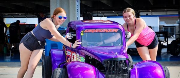 Sisters, Gracie and Makenna Crocker work together to push Gracie’s Legend Car into the garage in preparation for another Cook Out Summer Shootout competition. 