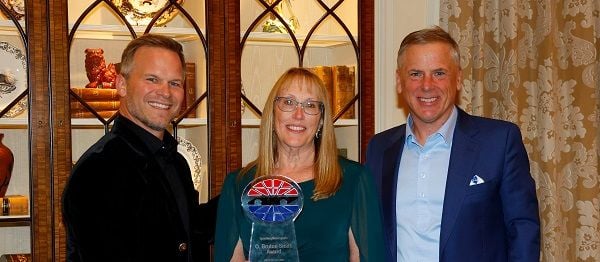 Charlotte Motor Speedway Senior Director of HR and IT, Susan McKee (center), received the coveted O. Bruton Smith Award from Speedway Motorsports CEO Marcus Smith (left) and Mike Burch, the company's Executive Vice President and Chief Operating Officer. 