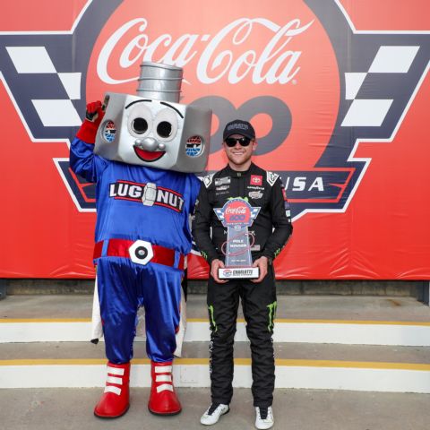 Ty Gibbs, right, poses with the Coca-Cola 600 pole winner's trophy alongside Lug Nut, the official mascot of Charlotte Motor Speedway, after Gibbs won the pole for Sunday's Coca-Cola 600.